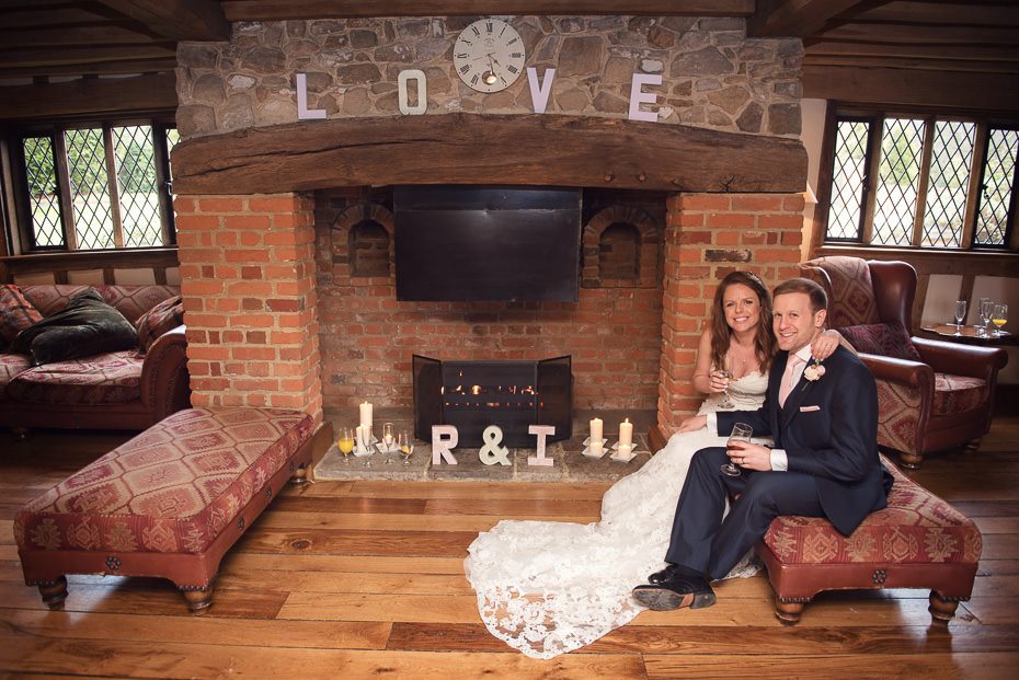 The bride and groom sit fireside at Cain Manor