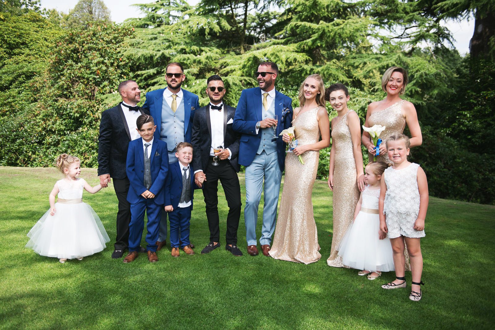 Stylish and relaxed group photo of a same sex wedding with bridesmaids and grooms men.