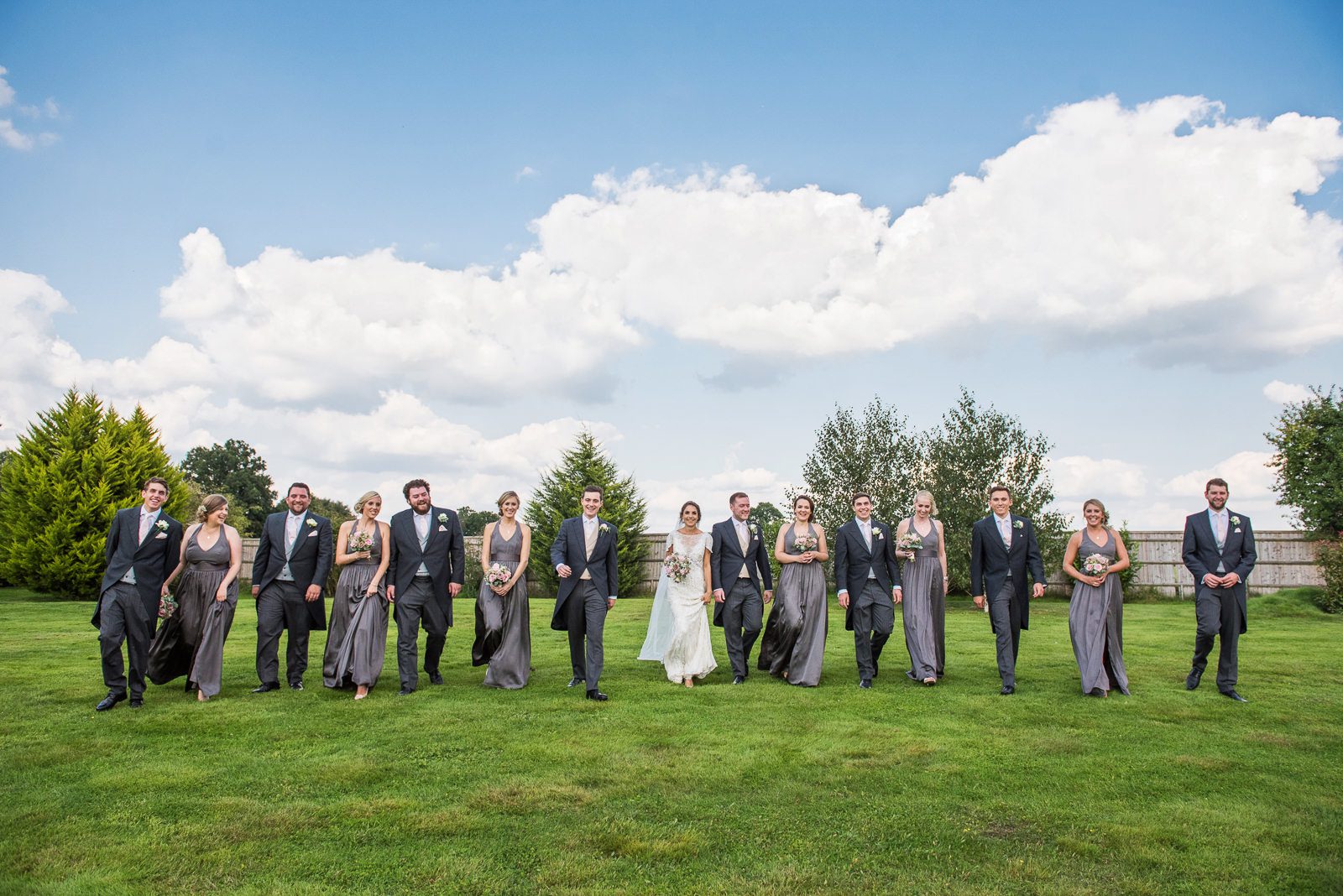 Fun and fabulous walking shot of the bridal and grooms parties walking together smiling.