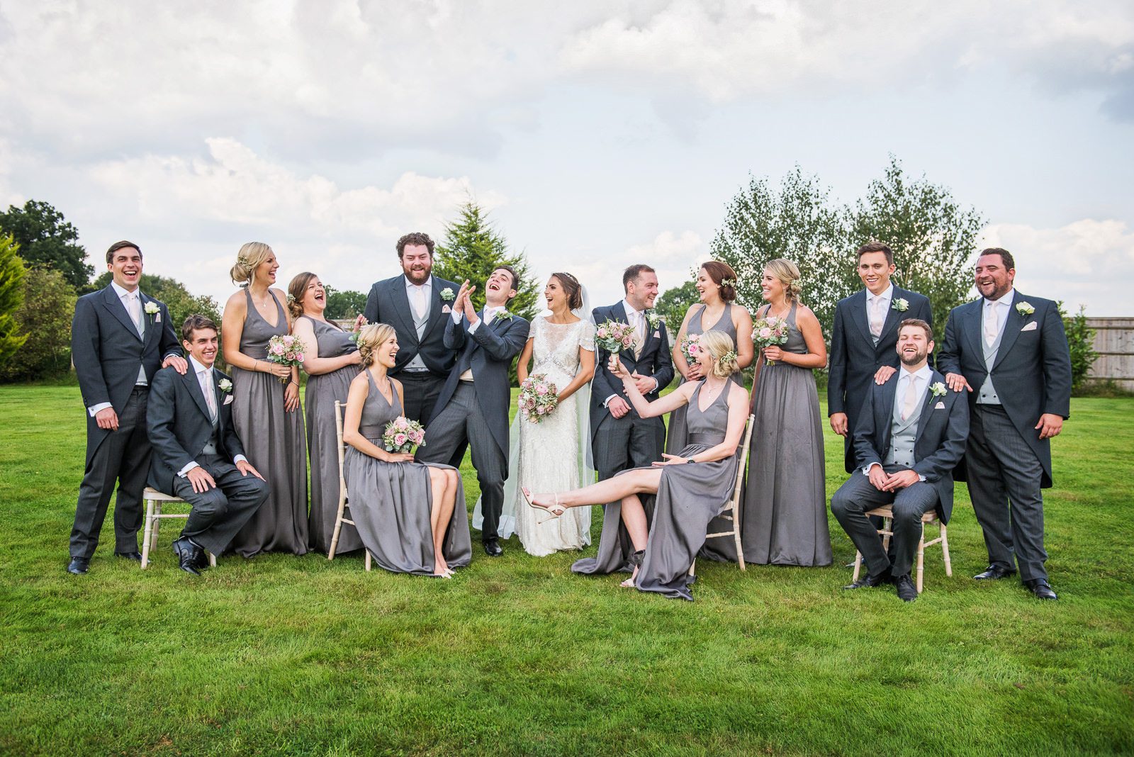 Original ideas for a fun fabulous group shot with sitting standing and laughing wedding party.
