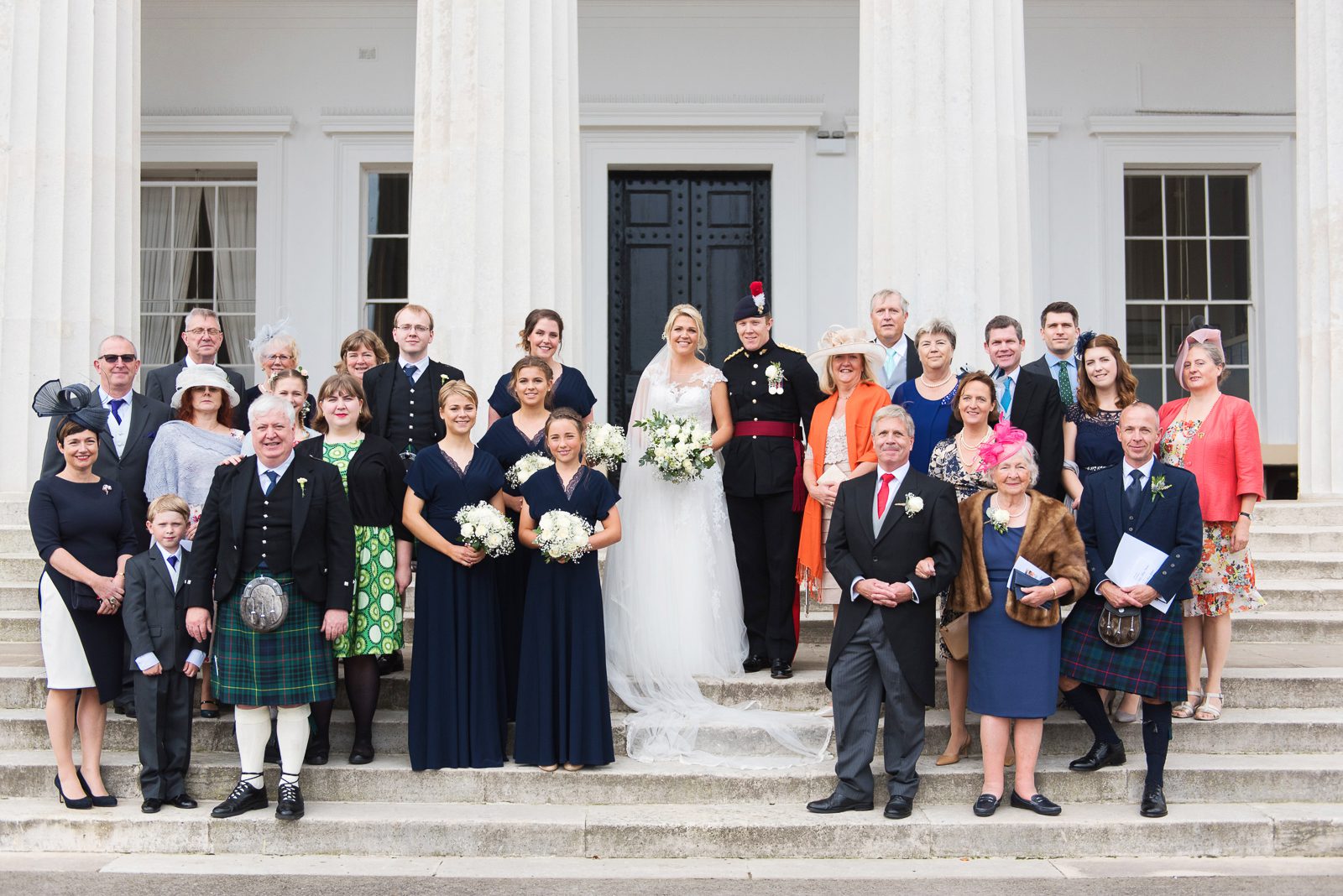 A group photograph of wedding guests on the steps of the staff college at the RMAS.