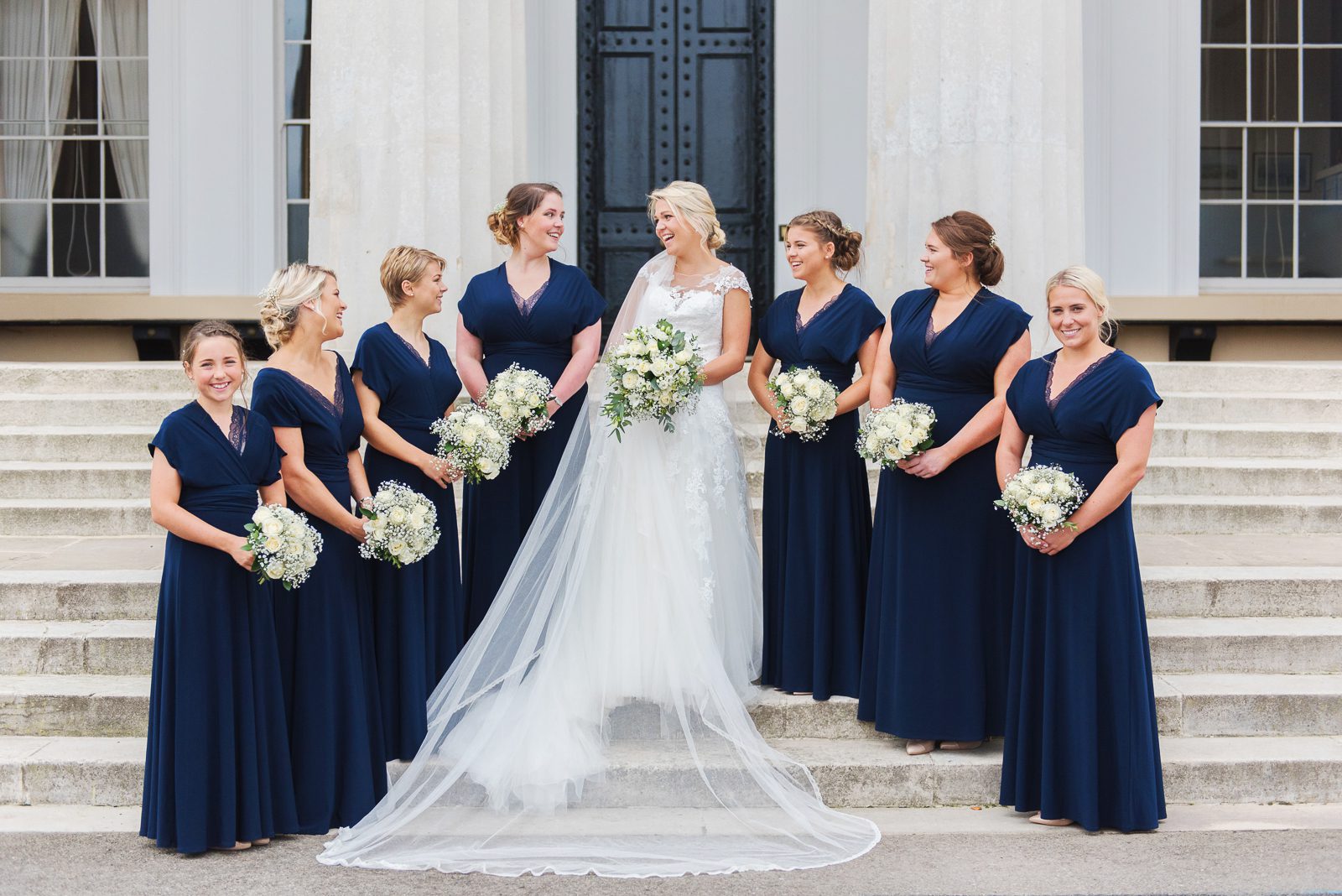 The bride and her bridesmaids have a photograph taken together on the steps of the staff college at the Royal Military Academy Sandhurst during a September wedding.