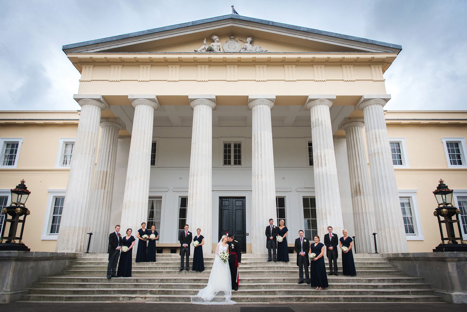 Stylish and alternative group shot of the wedding party for a military wedding at Sandhurst military Academy by local photographer Juliet Mckee.