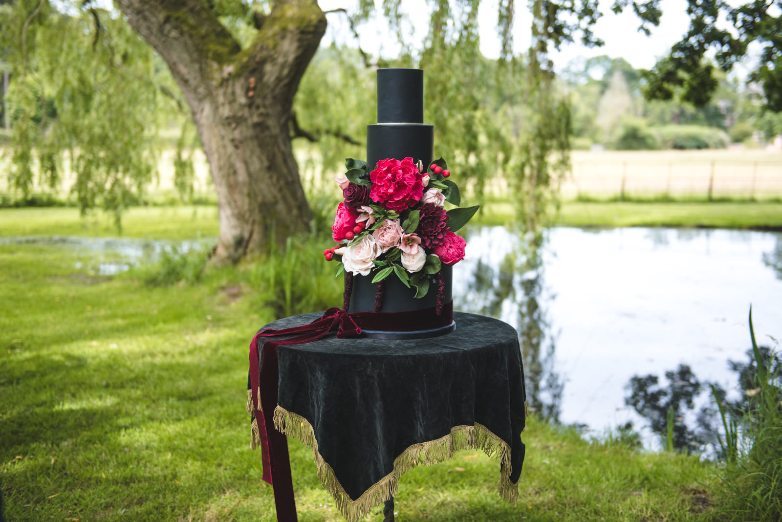 Dark charcoal wedding cake with large sugar flower work.