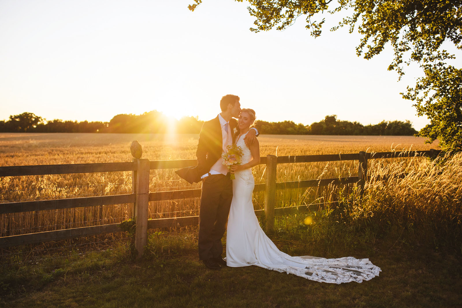 Hampshire wedding photographs taken by a corn field at sunset.