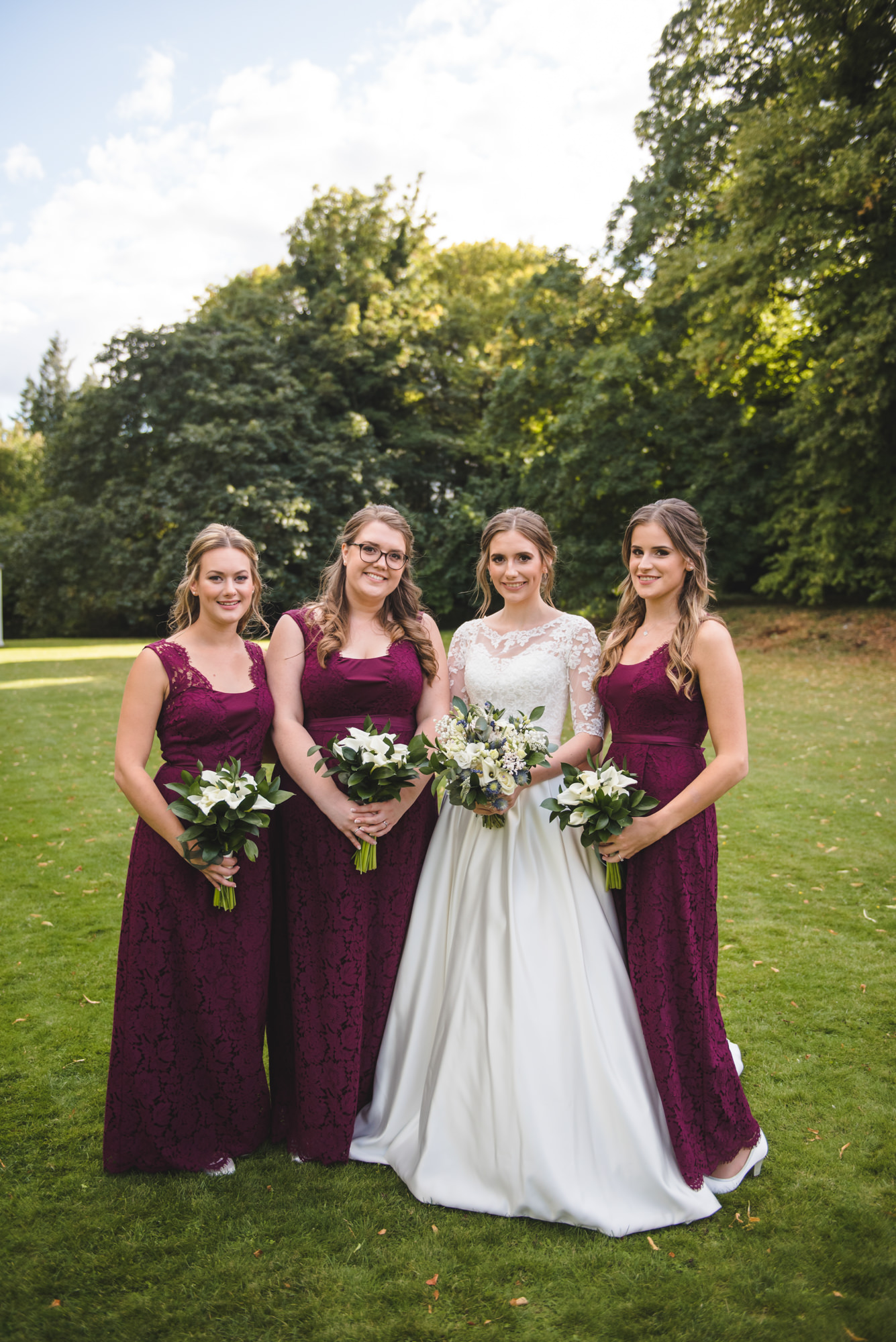 bridesmaids wearing burgundy lace dresses.